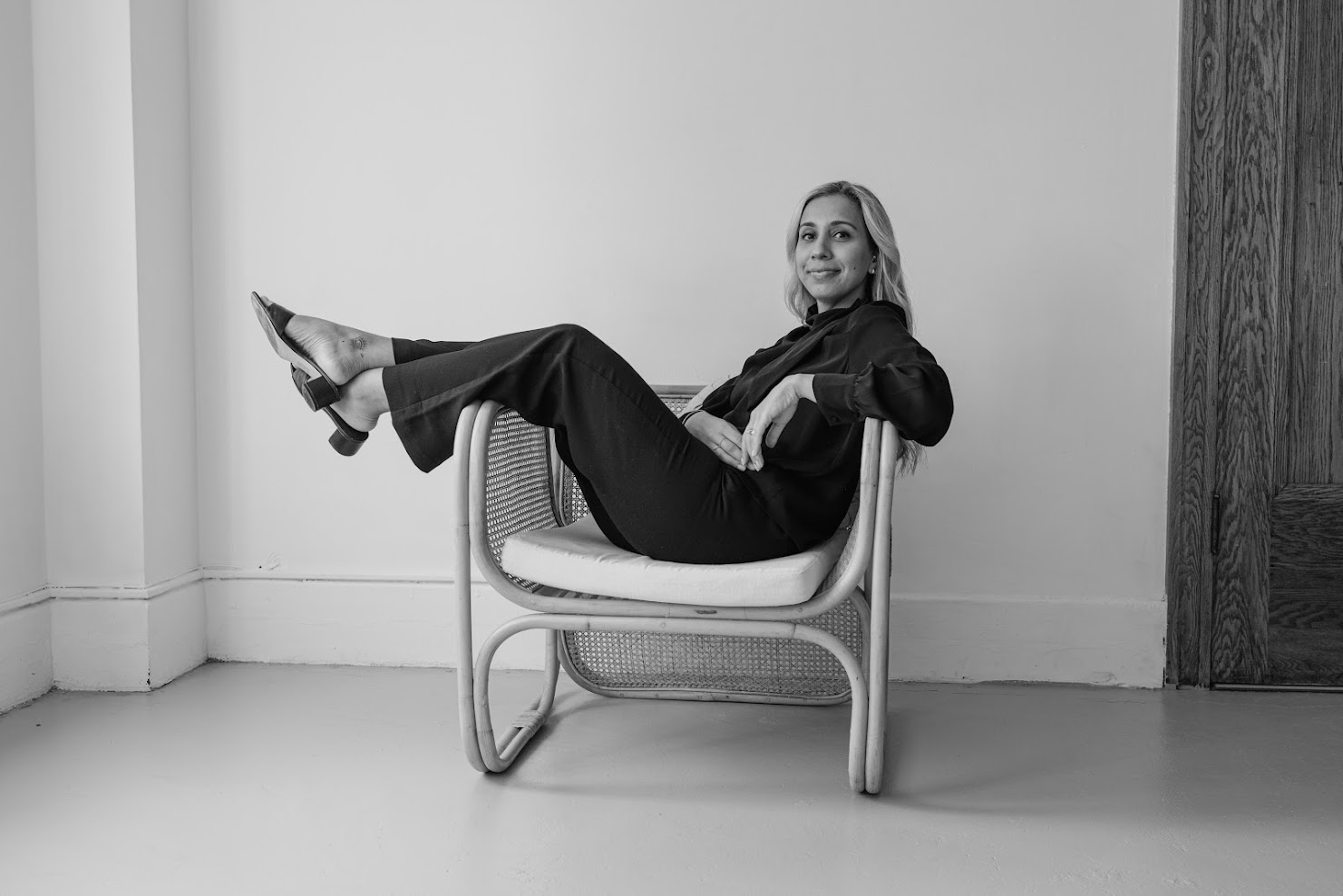 Tania Gill seated in a rattan chair